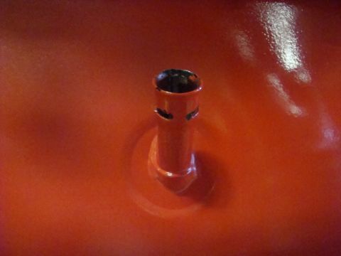 1989 Ford Bronco - Close-up of a red metal component a cylindrical protrusion with ventilation slots.