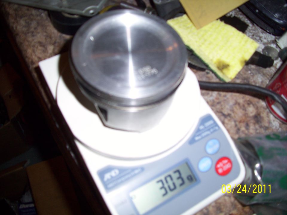 Piston on digital scale showing 303g. Date stamp 08/24/2011