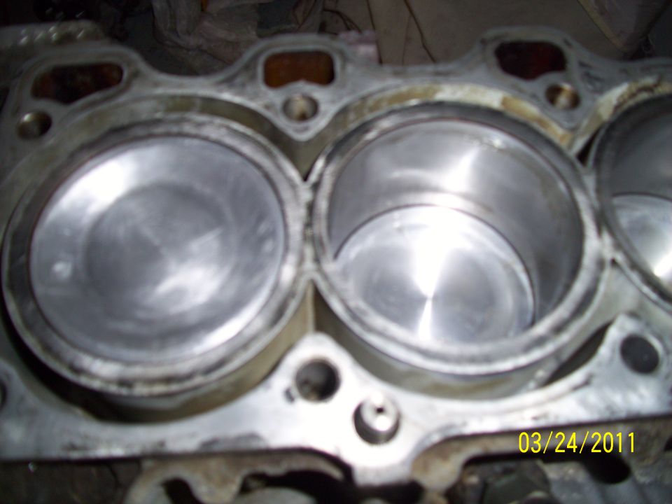 Close-up of engine block cylinders. Date stamp 03/24/2011 and SUPERMOTORS.NET watermark visible