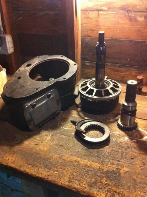 1989 Ford Bronco - Various components of a transfer case, including gears and housings, are displayed on a workbench.