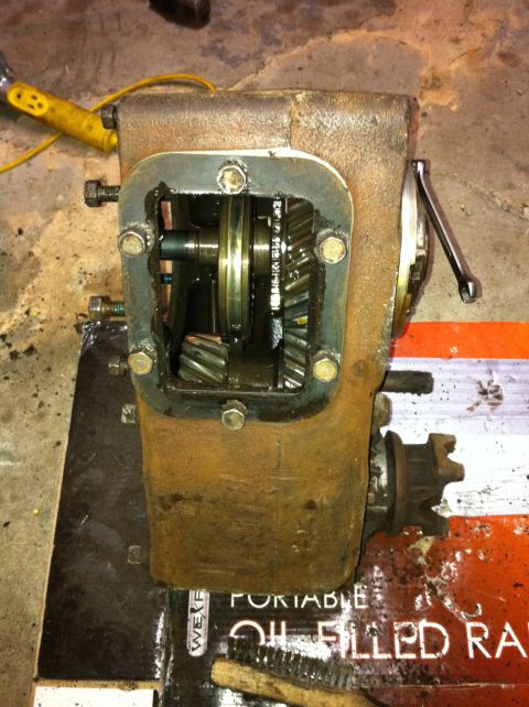 1989 Ford Bronco - This is a close-up view of a rusty transfer case with its internal gears visible. A wrench is attached to the side of the unit.