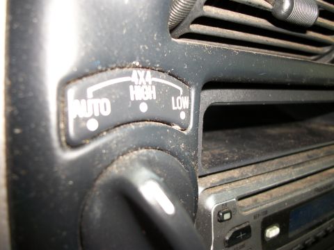 1994 Ford Explorer - Close-up of the 4x4 control dial and selector buttons inside a vehicle, showing options for AUTO, 4X4 HIGH, and LOW.