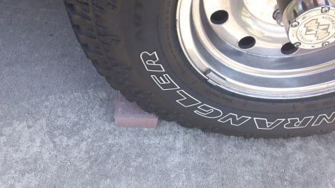 1994 Ford Bronco - A tire and wheel are visible, with a brick placed under the tire for support.
