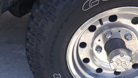 1994 Ford Bronco - A close-up shot focuses on the wheel and tire of a vehicle, revealing details of the hub assembly.