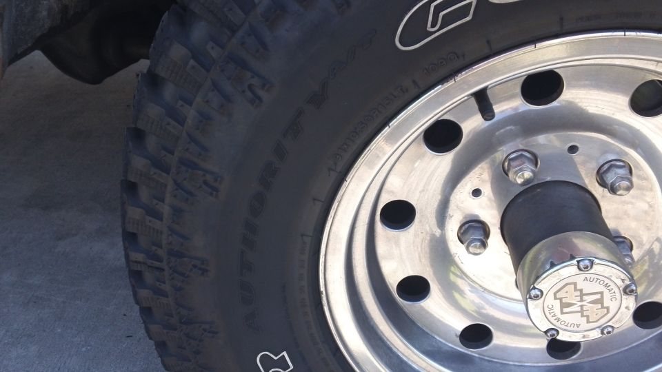 Close-up of a vehicle's wheel with a tire. The hub has an 'automatic' marking
