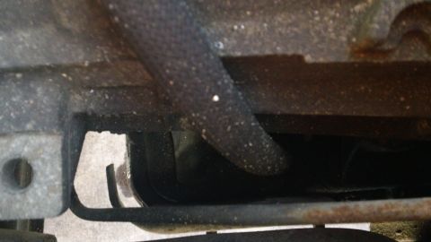 1994 Ford Bronco - Close-up of a vehicle's underside, showing a black hose and part of the frame. The Supermotors.net logo is visible at the bottom right.