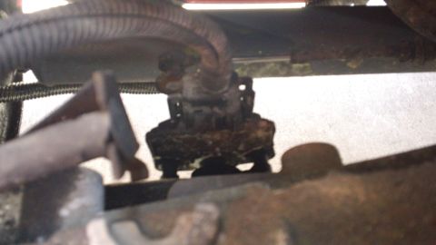 1994 Ford Bronco - Underside view of a greasy mechanical part, possibly from an engine bay.
