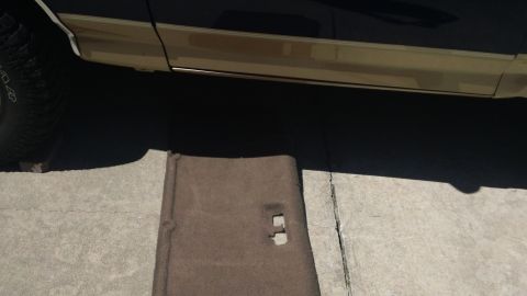 1994 Ford Bronco - A removed interior panel lies on the ground next to the side of a vehicle.
