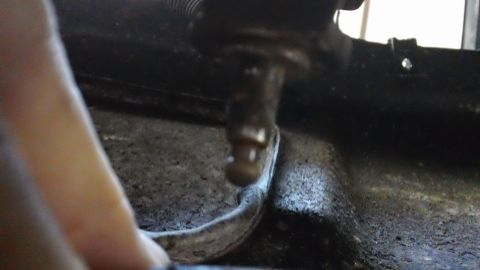 1994 Ford Bronco - A close-up view of a metal component and a flexible hose, likely part of a vehicle's mechanical system.