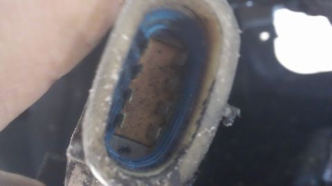 1994 Ford Bronco - A close-up view of a component within the vehicle's interior, showing dirt and a blue lining.