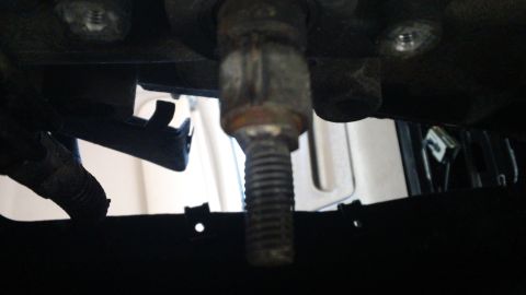 1994 Ford Bronco - Close-up view of a bolt and bracket, likely from a vehicle's undercarriage.