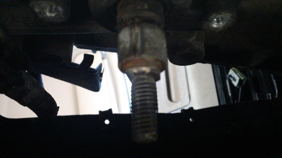 close-up of a bolt threaded into a metal bracket
