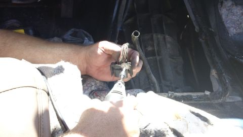 1994 Ford Bronco - Hands are seen working on a wiring harness inside a vehicle's interior, likely for repair or modification.