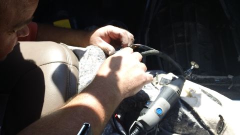 1994 Ford Bronco - Working on the wiring harness inside the vehicle's cabin.