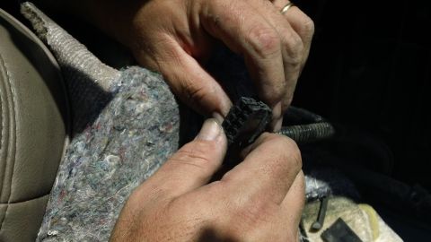 1994 Ford Bronco - A person is shown connecting an electrical connector inside a vehicle's interior.