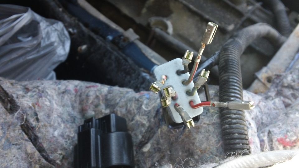 Wiring harness connector with multiple wires attached to a white terminal block