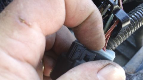 1994 Ford Bronco - A hand is shown connecting an electrical harness connector, with visible wires.