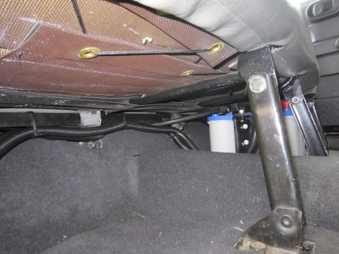 2008 Jeep Wrangler - Detail of the underside of a car seat, showing wiring and auxiliary canisters.