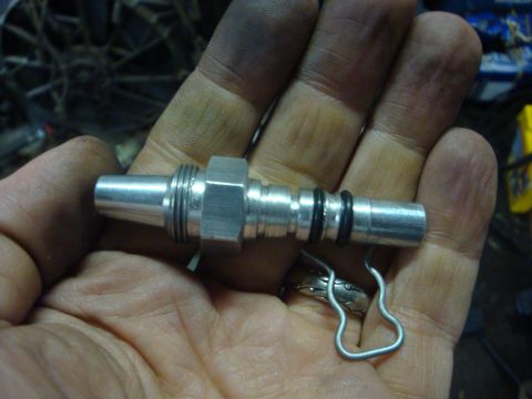 1989 Ford Bronco - A metal fitting with o-rings is held in a hand, likely a part for a vehicle rebuild.