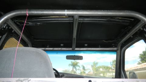 1997 Ford Ranger - The interior of a vehicle shows a custom roll cage installed around the cabin.