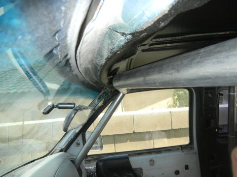 1997 Ford Ranger - The interior of a vehicle shows a metal roll cage structure installed around the cabin area.