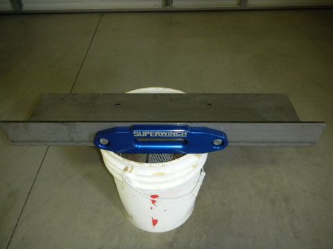 1997 Ford Ranger - A blue Superwinch part is mounted on a metal plate, which is placed over a white bucket.