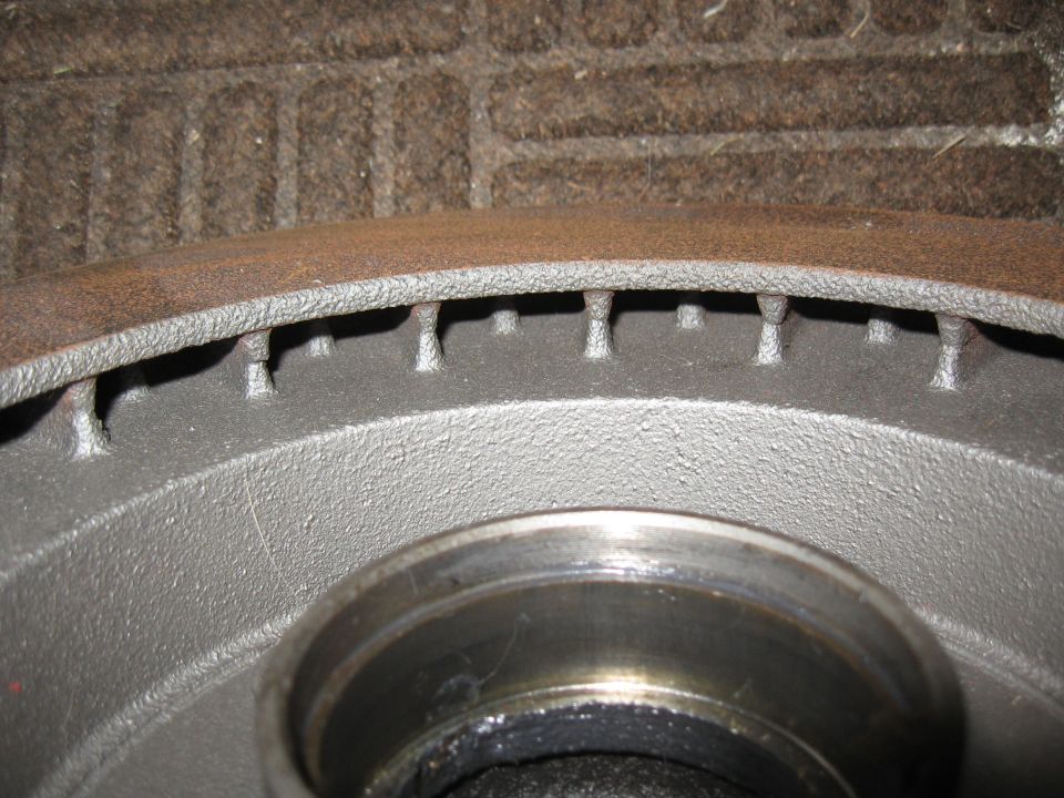 Close-up of a vented brake rotor with rust on the outer edge