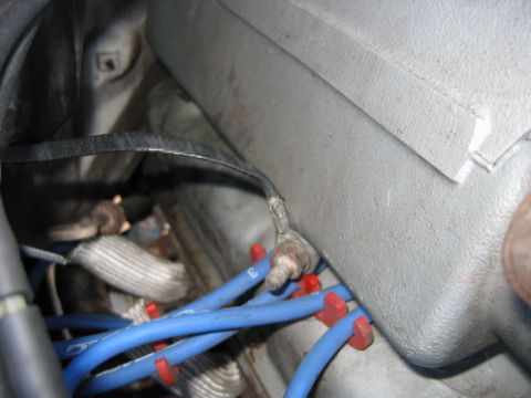 1992 Ford Bronco - Close-up view of blue spark plug wires and a ground strap in an engine bay.