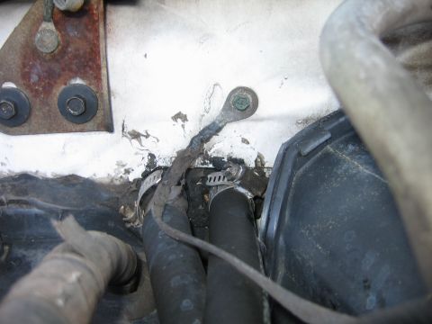 1992 Ford Bronco - Close-up of a ground wire and hoses in an engine bay.