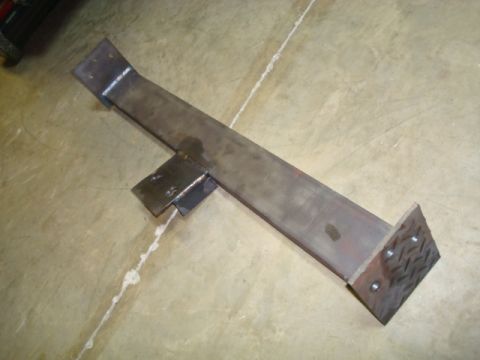 1995 Ford Bronco - A fabricated metal bracket with a diamond plate foot is shown on a concrete surface.