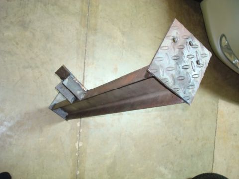 1995 Ford Bronco - A custom-fabricated metal bracket, a diamond plate surface, rests on a concrete floor.