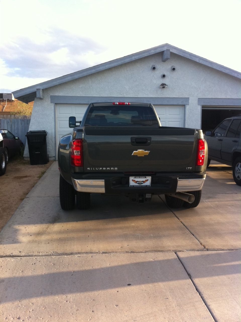 Rear of dark gray Chevrolet Silverado dually pickup in driveway