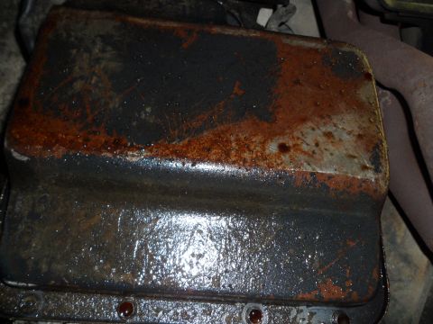 1989 Ford Bronco - This is a close-up view of a vehicle's oil pan, showing signs of rust and oil accumulation.