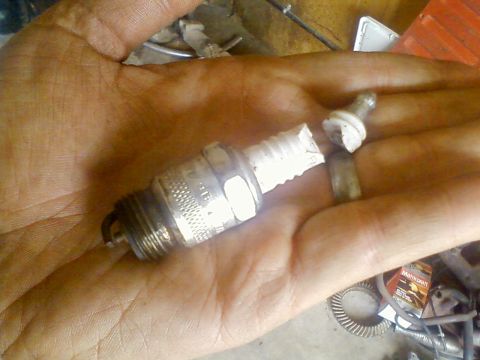 1981 Ford Bronco - A damaged spark plug, with a broken ceramic insulator, is held in a person's hand.