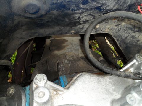 1989 Ford Bronco - Close-up view of engine bay components, including a black hose and metal parts.