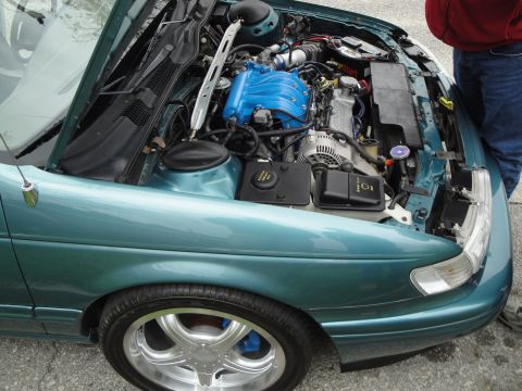 2003 Ford Taurus - A teal car's engine bay is open, revealing the engine and various components.