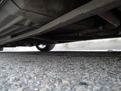 2003 Ford Taurus - Low angle shot of a car's undercarriage, revealing the exhaust and a wheel.