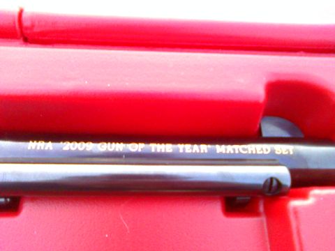 2006 Ford E350 - Close-up of engraved text on a dark barrel, identifying it as the NRA 2009 Gun of the Year Matched Set.