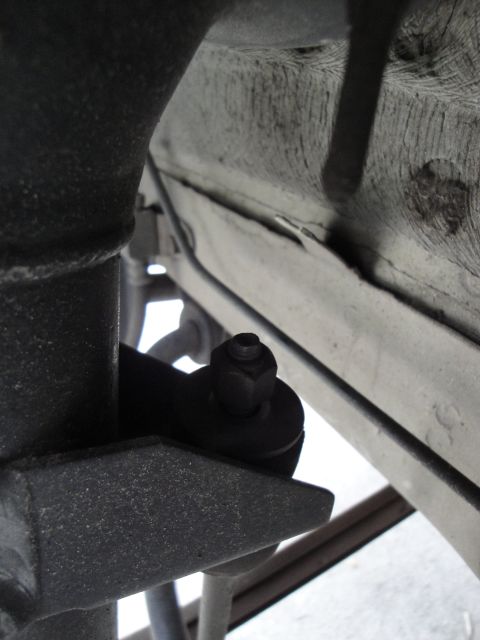 2003 Ford Taurus - A close-up view of a vehicle's undercarriage, focusing on a suspension component with a bolt and nut.