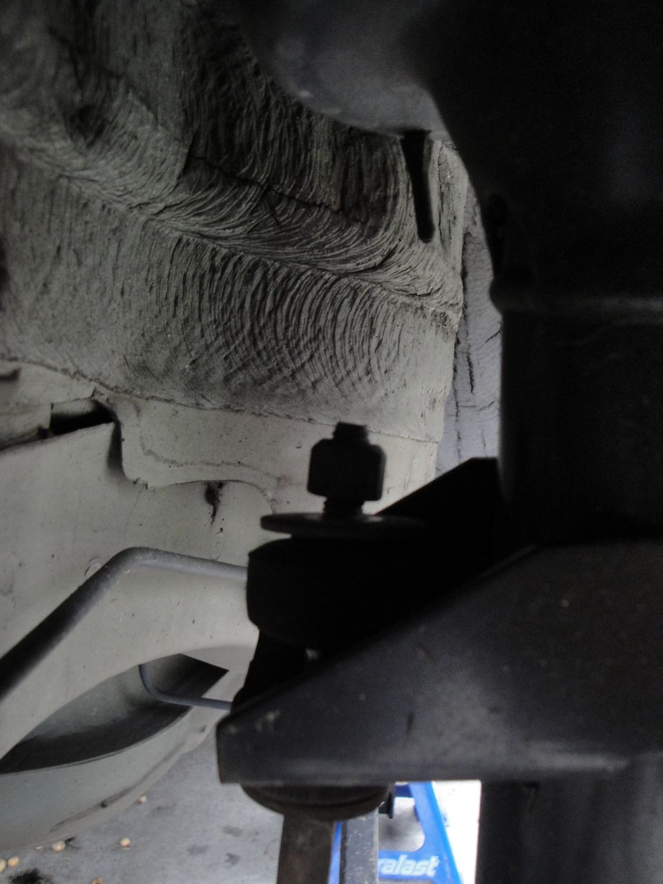 Close-up of a car's suspension linkage with a bolt and nut
