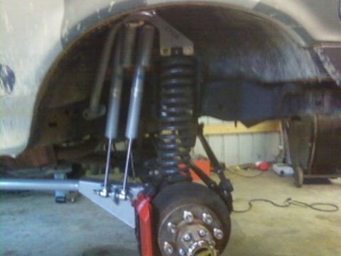 1995 Ford Bronco - Detail of a vehicle's suspension system, showing modified components and a wheel assembly.