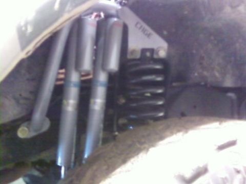 1995 Ford Bronco - Close-up view of suspension components, including coilover shocks and a bracket labeled 'CHGE'.