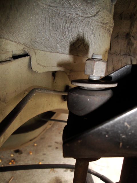2003 Ford Taurus - A close-up view of a vehicle's suspension system, focusing on a nut and washer assembly.