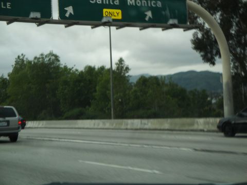 2003 Ford Taurus - Driving on the highway under a cloudy sky with a directional sign overhead.
