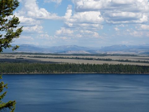 2006 Ford E350 - A wide landscape shot shows a calm lake, a dense forest, and rolling hills leading to mountains.