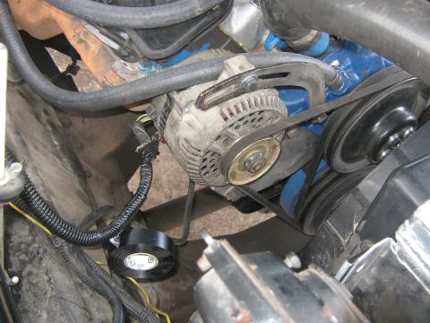 1972 Ford F-250 - Close-up view of the alternator and serpentine belt system within an engine compartment.