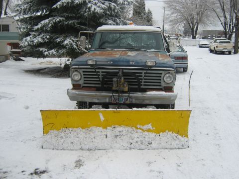 1972 Ford F-250 - This 1972 Ford F-250 is equipped with a front-mounted yellow snow plow, ready for winter conditions.