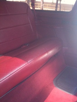 1995 Ford Bronco - Interior view of a vehicle's red leather rear seat and floor.