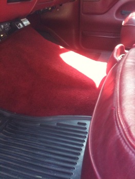 1995 Ford Bronco - Interior view of a car with red carpeting and seating.