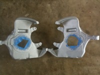 1995 Ford Bronco - Two identical silver metal parts are shown laid out on a concrete surface.